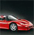 Red convertible sports car with white soft top, silver wheels, and visible driver silhouette against dark background.