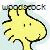 Yellow cartoon character with black outline, two small eyes, and a smiling mouth; background is light blue gradient.
