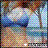 Pixelated static image with abstract color blocks in blue, gray, brown, and white tones forming indistinct shapes.