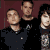 Group of people in dark and light clothing with a maroon background, featuring pixelated text elements 'm', 'mc', and 'mcr' on black sections.