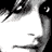 A black-and-white close-up of a person's face with visible eyes, nose, and mouth; the lower portion features pink lips and partial text on a white background.