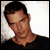 Static pixelated image of a person with short dark hair wearing a black shirt against a light background.