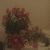 A static image of a dark-haired figure with red flowers in the foreground and background, set against a light brown backdrop.