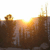 A pixelated static image shows a bright sunburst over a dark brown landscape with two rounded structures on the left and right edges.