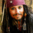 A pixelated image of a person with long dark hair and a maroon headband, wearing multiple necklaces against a black background with white text.