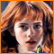A pixelated image of a person with long red hair and blue eyes, wearing dark clothing, with 'FAN' text in green and yellow at the bottom right.