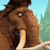 Pixelated brown mammoth with large curved tusks, single visible eye, and textured fur against a light blue sky and green foliage background.