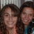 Two people with dark curly hair smiling closely together in a static image.