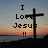 Pixelated image showing a cross silhouette against a sunset sky with text reading "I Love Jesus !!" in blocky font.