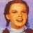 Pixelated image of a person with brown hair and closed eyes on left, blue background with white text reading It's all over the [rainbow] on right.