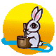 Pixelated bunny with pink inner ears and large black eyes sits before a brown mortar, holding a pestle that shifts position across frames against a yellow-orange gradient background.