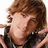 Pixelated image of a person with brown hair and a black choker necklace, next to red background with black text reading "omg he is hot".