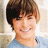 A pixelated image of a smiling person with brown hair wearing a light blue shirt, split into four quadrants with text on two sections.