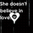 Pixelated black background with white text reading "She doesn't believe in love" and a heart-shaped icon below the text.