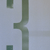 A pixelated green and gray abstract shape with a central cross-like form on a light blue background.