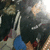 A pixelated image of a dark-haired figure with blue and red accents, partially obscured by motion blur.