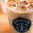 A split-screen image with a coffee drink on the left and text on the right, featuring a blueberry on the drink's surface.
