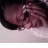 A static pixelated image shows a dark, blurred figure with indistinct features against a light background, lacking clear subjects or text.