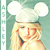 A static image of a person with long blonde hair wearing a white knitted hat with two large round ears, set against a light blue background with vertical text reading "ASHLEY" on the left.