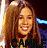 A 47x48 pixel animated contact sheet showing two frames of a woman with long brown hair smiling, wearing a dark top and white text "CAMILLE" at the bottom against a blurred background with blue light streaks.