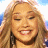 Pixelated image of a smiling person with long light brown hair, next to text reading 'The REAL American Idol' on a blue cloud-shaped background.