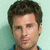 A pixelated image of a person with short brown hair against a light green background, showing two states: one without text overlay and another with blue text reading "shawn" over the eyes.