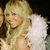 A blonde woman with feathered white angel wings smiles while clapping, shown in a of four with slight variations in lighting and expression
