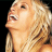 Pixelated close-up of a person's face with blonde hair, mouth open in an expressive pose against a black background.