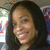 A static pixelated image shows a person with dark hair and a light skin tone smiling, with a blurred background containing indistinct shapes and colors.