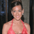 Pixelated image of a person in a red halter top against a dark background with vertical elements.