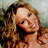 Static pixelated image of a person with long wavy hair and visible facial features against a blurred background.