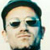 Pixelated static image of a person's face with dark hair and blue-toned shading on the right side, displayed as a 50x50 buddy icon.