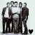 Static black-and-white image of six men in suits standing side-by-side, with a small heart symbol below the leftmost figure.