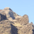 Pixelated landscape with rocky formations under a light blue sky, showing no visible text or distinct objects.