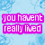 Pixelated text in bright pink on a light blue floral background with a gray rectangle overlay.