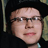 Static 48x48 pixel icon showing a close-up of a person's face with glasses, dark hair, and light skin tone against a black background.