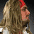 Four of a pixelated animated icon showing a shirtless man with long blonde hair and beard in various poses against dark background