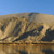 A static pixelated image shows a landscape with a blue sky above a brownish terrain featuring dark patches and a horizontal line across the middle.