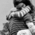Black-and-white image of a person in striped clothing holding a child, with overlaid text reading "Never Let Go" on the left and "Noah Wing 8.3.08" on the right.