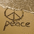 A static image showing a peace symbol drawn in sand with the word 'peace' below it, alongside footprints and text reading 'Summer 09'.