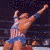 Animated sequence showing a muscular man in wrestling attire performing various poses against dark and blue backgrounds.