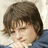 A pixelated image split into two sections: a person with brown hair on the left and blue text on a green background on the right.