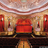 A pixelated image of a theater interior with red seats, golden walls, and a ceiling with white and brown stripes.