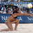Pixelated beach scene shows a woman in bikini crouching on sand with arms extended, background includes blue banner and spectators.