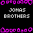 Pixelated icon with repeating pink border shapes and white text reading "JONAS BROTHERS" on black background, with gray area on right side.