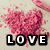 A pixelated heart-shaped arrangement of pink particles with the word LOVE below it on a light background.