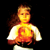 Pixelated figure with long brown hair holds glowing orange-yellow object against black background, text reads 'blondes', 'ABOUT A FEB 24 BURNING FIRE 2004'