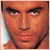 Pixelated close-up of a person's face with warm orange and brown tones, showing eyes, nose, mouth, and partial neck against a light background.