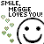 Pixelated text reads 'SMiLE, MEGGiE LOVES YOU!' above a large smiley face with black eyes and a curved mouth, surrounded by green pixelated hearts.