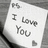 A black-and-white animated icon showing a note with 'I Love You' text, floating hearts, and partial script reading 'Fight'.